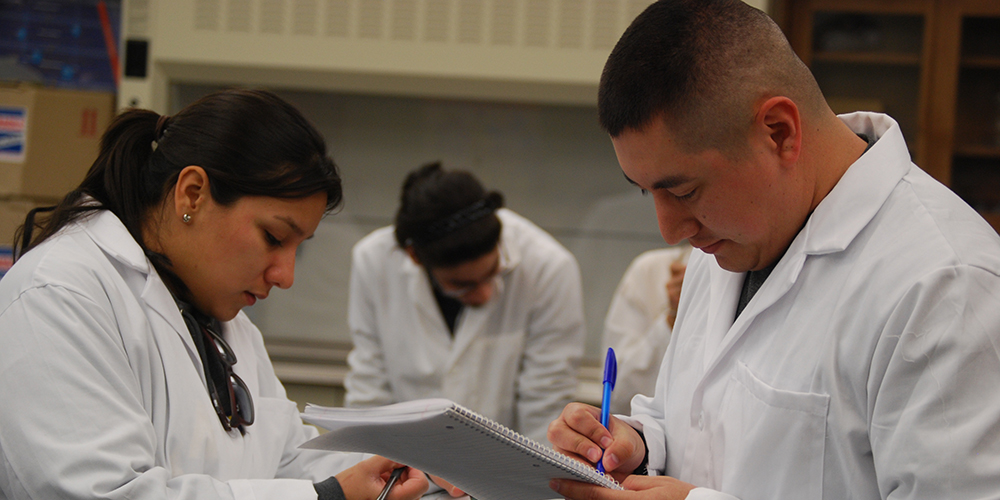 Students in Labcoats Taking Notes